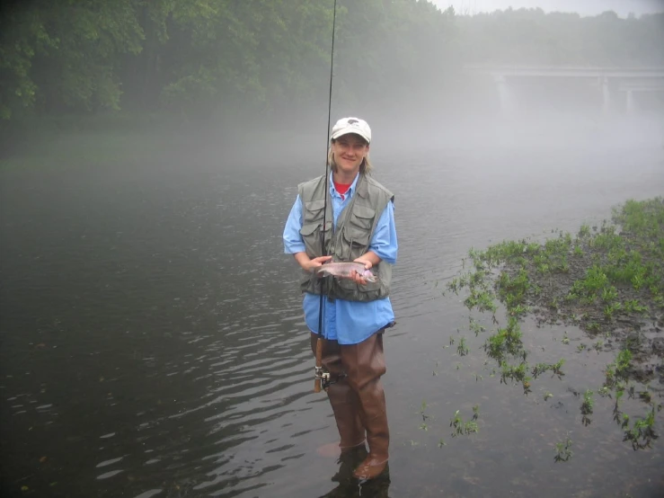 a person with a fishing rod standing in the water