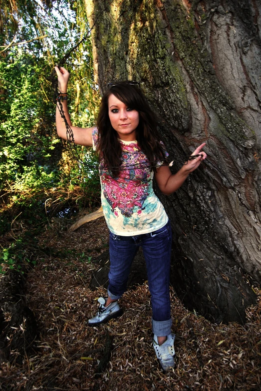 a beautiful  standing by a tree in the woods