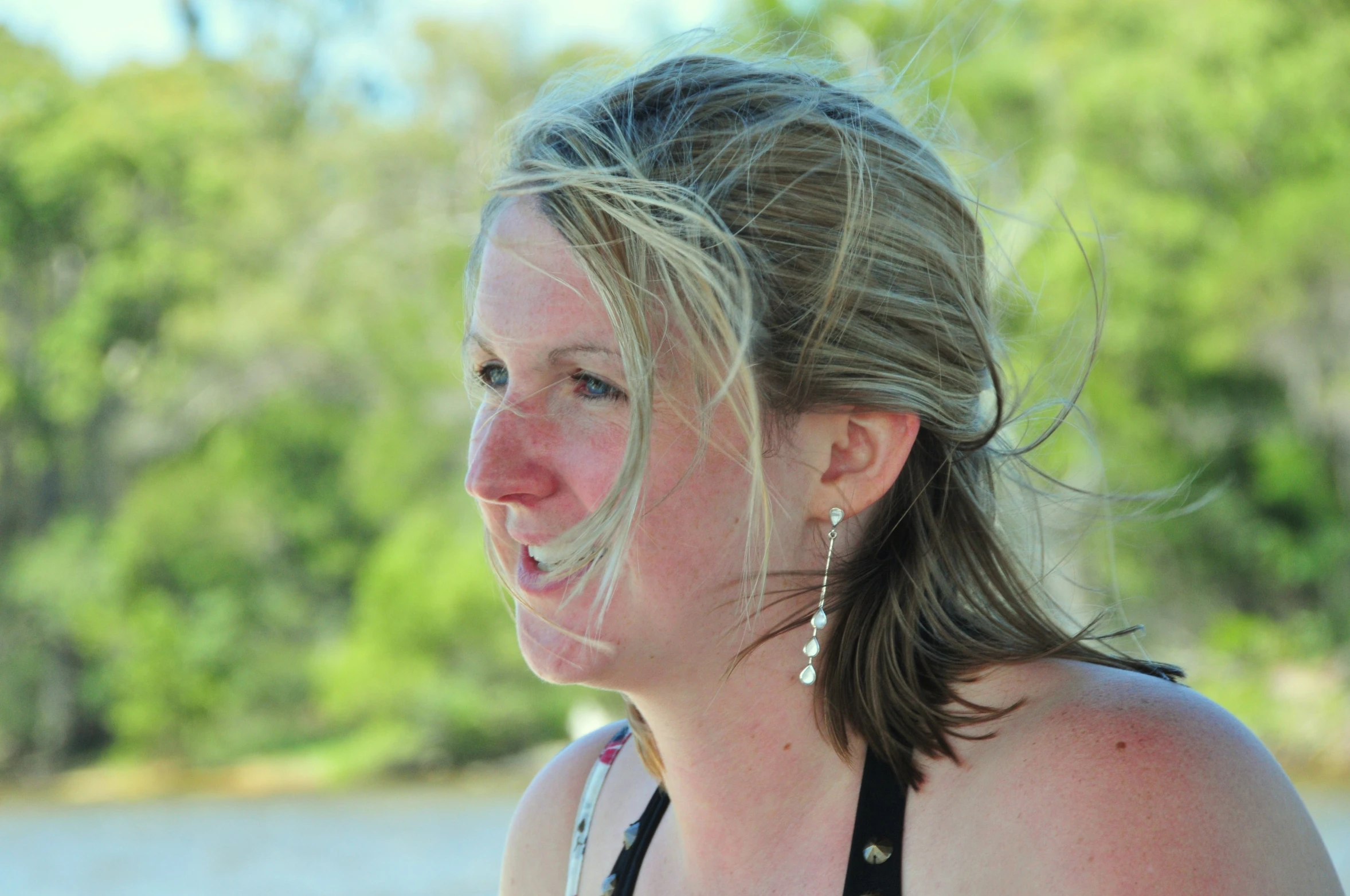 a woman is talking on her cellphone at the beach