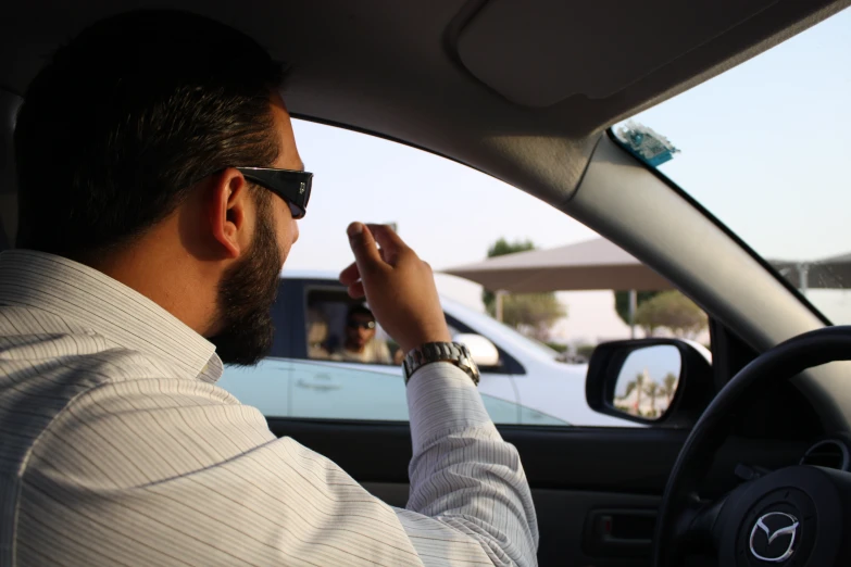 a man holding a cigarette while driving a car