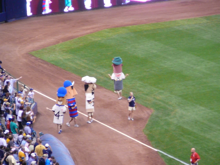 two people are walking towards the stands at a baseball game