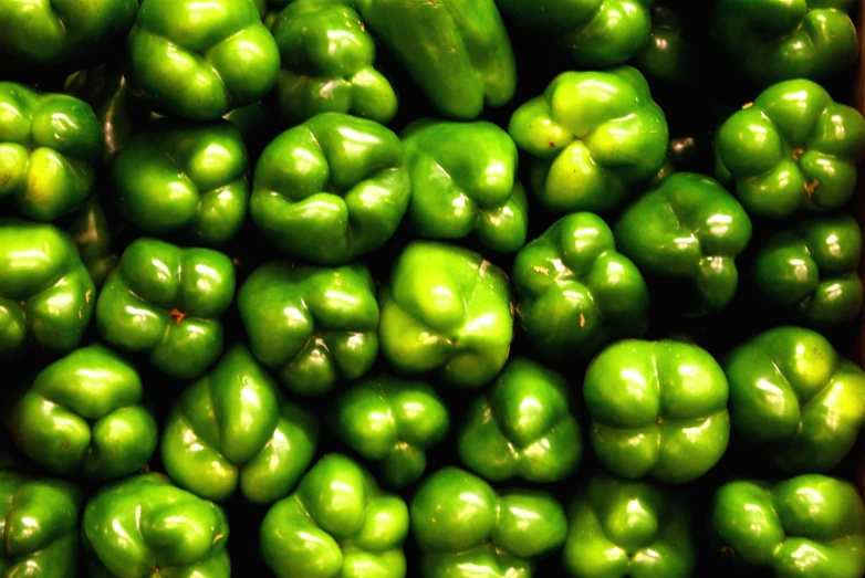 a pile of green peppers that have been bought for sale
