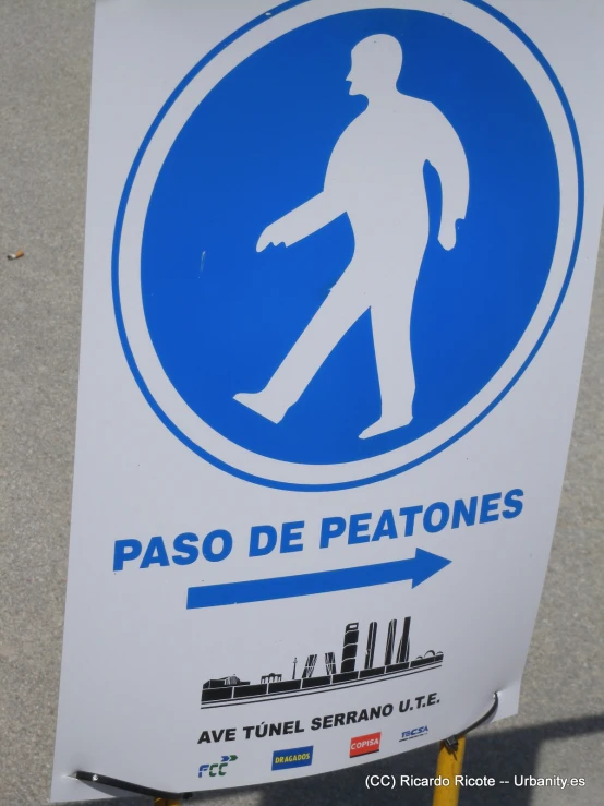 a blue and white sign indicates a man on crosswalk