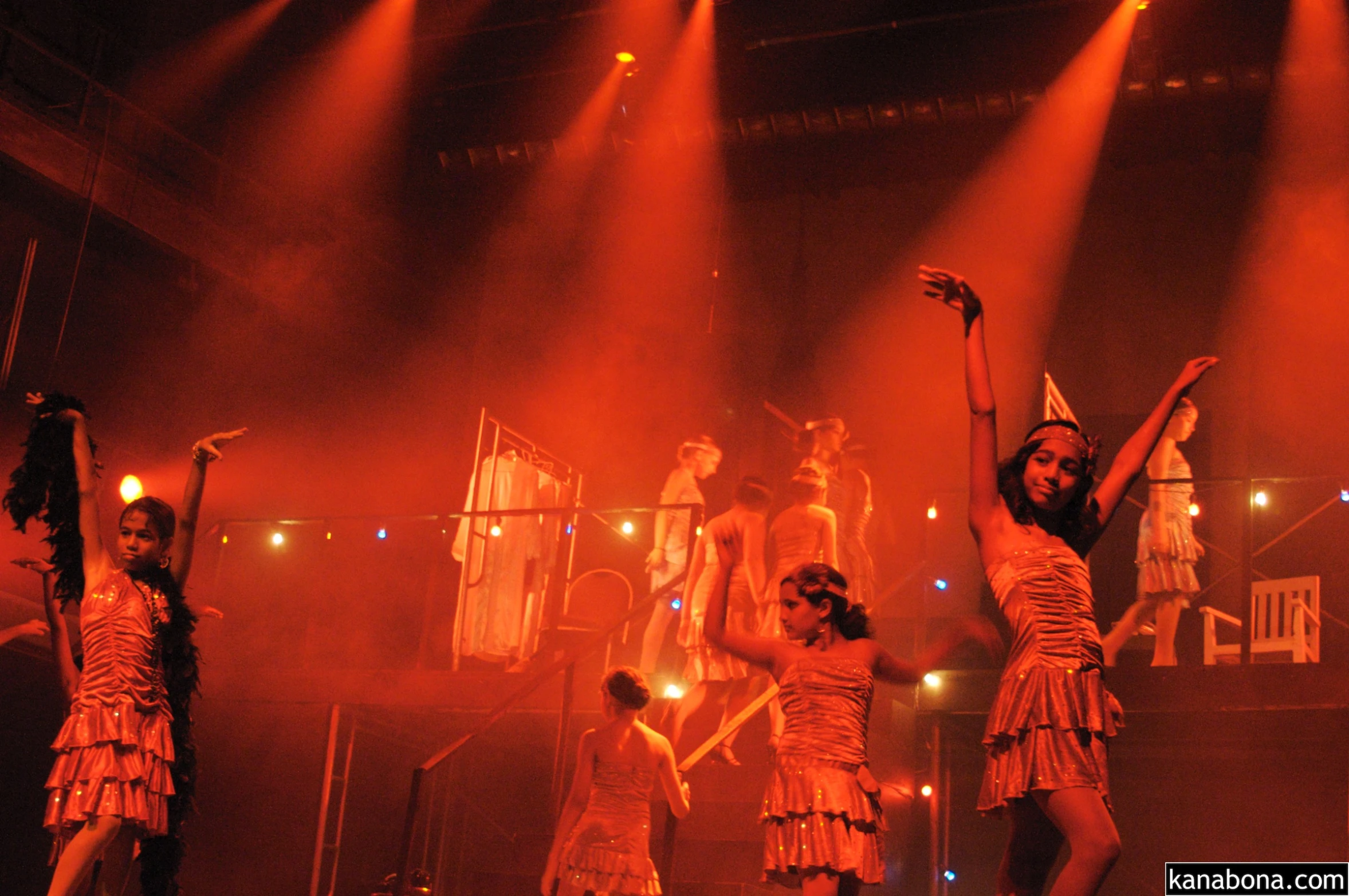 several women wearing dressy outfits standing on stage