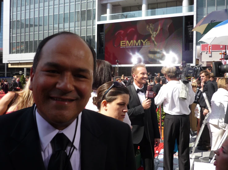 a man in a suit is smiling and surrounded by pographers