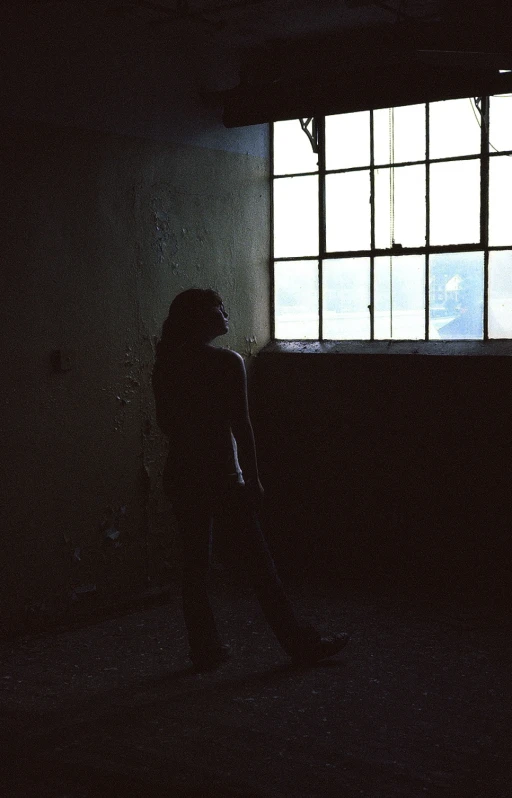 a woman stands in front of a window at night