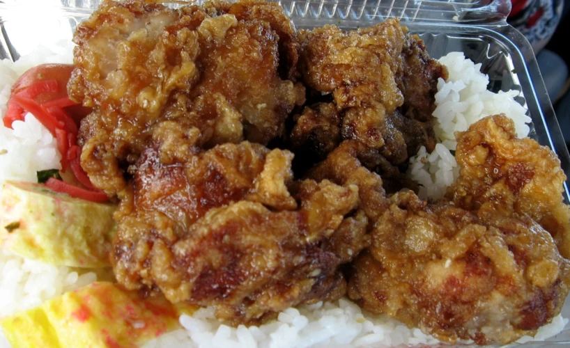 a meal in a styrofoam container with rice and vegetables