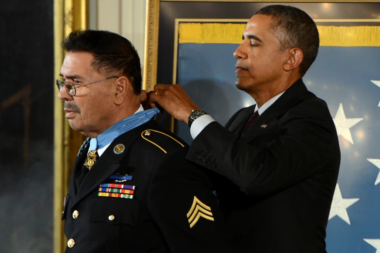 the president is adjusting the medal of military officers