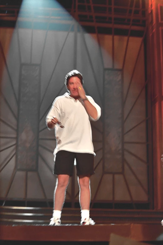 the man is standing on a stage in shorts