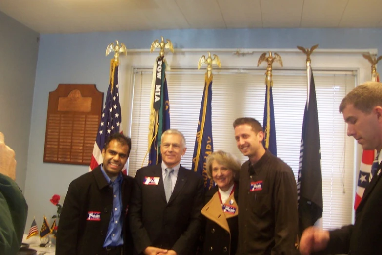 some people in suits and ties standing together with american flags