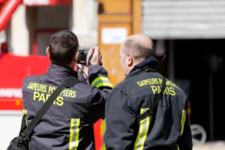 two fire fighters are taking a picture with a camera