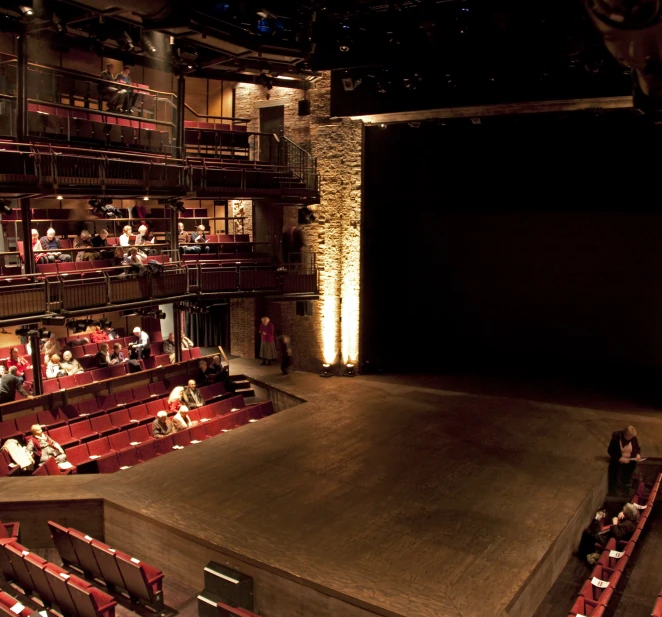 people in seats sit at a large stage