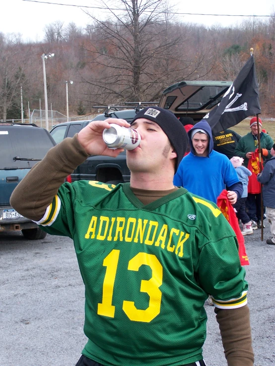 a man standing next to a woman drinking water