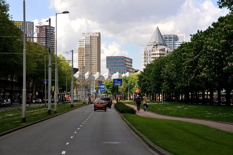 an empty street with cars, trees, and buildings