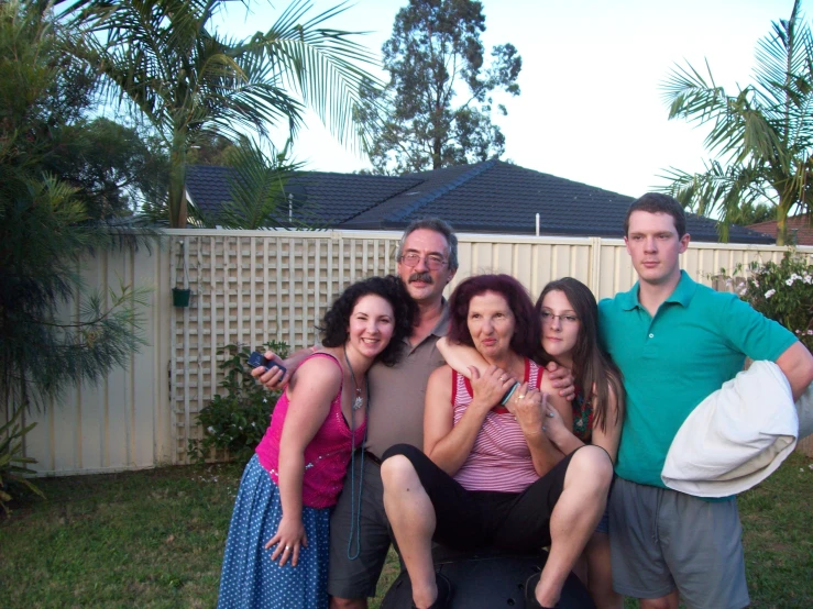 people are posing in front of a fence