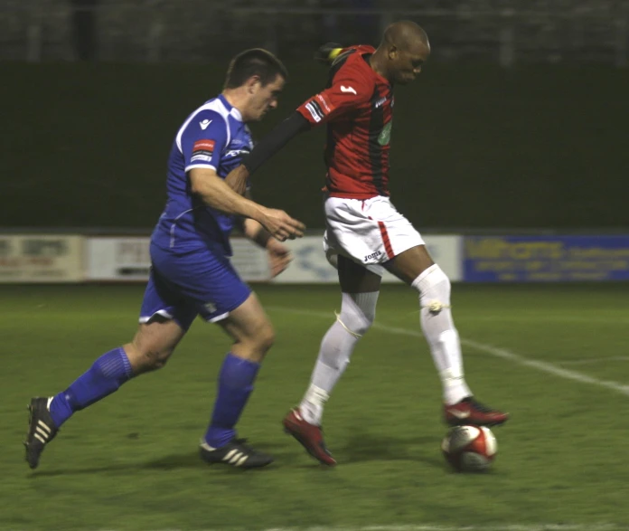 soccer players in action on the field during night