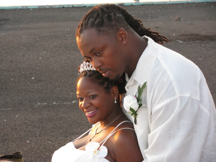 bride and groom with flowers on their hair sitting next to each other