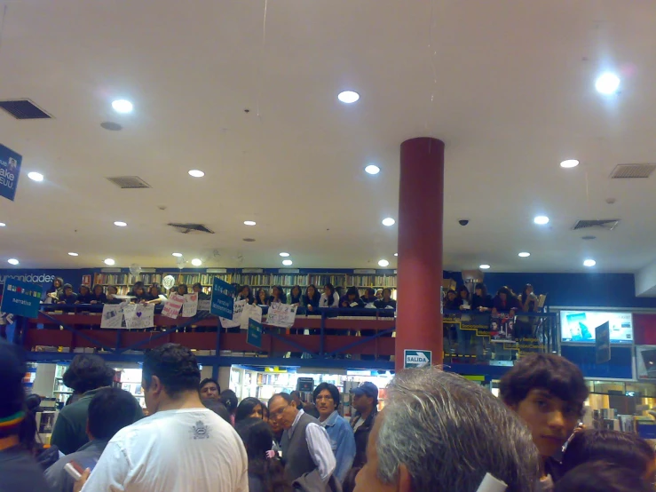 several people standing in a liry with many books