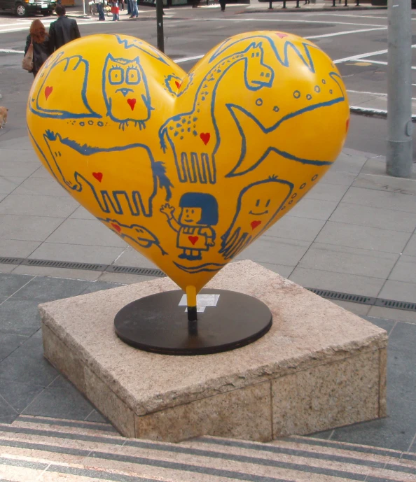a heart shaped balloon sits on a pedestal