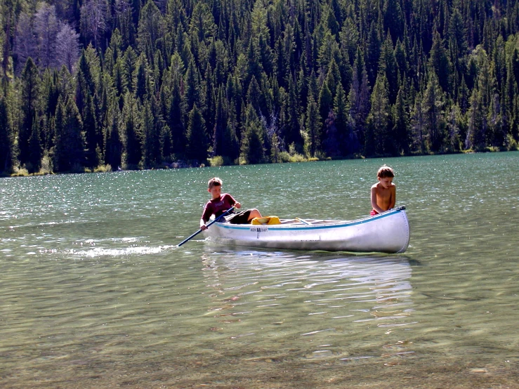 two people riding in the back of a small boat on water