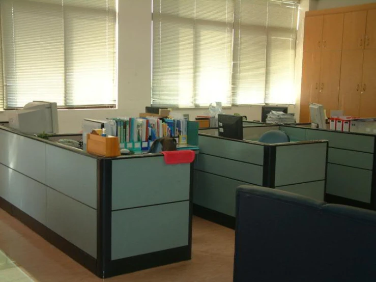 two office desks in an office with cubicles