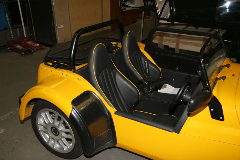 a yellow sports car parked inside of a garage