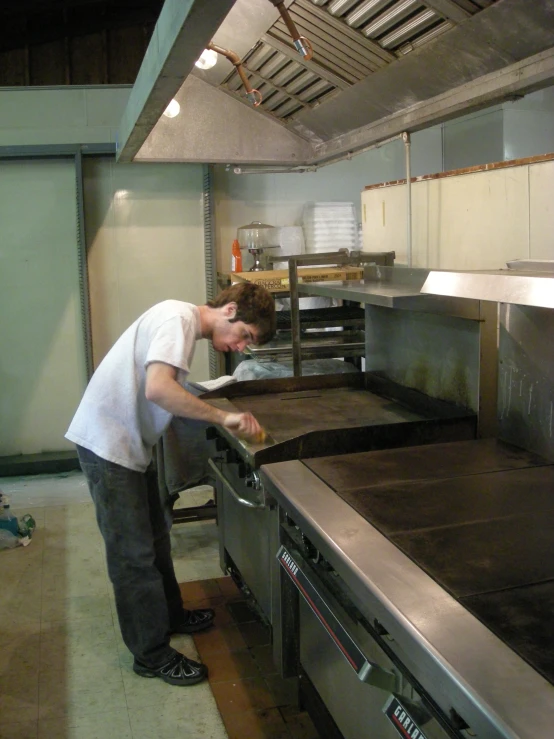 a man placing soing on a kitchen stove