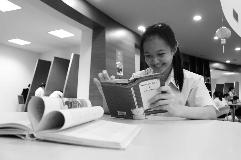 woman at a desk reading an open book