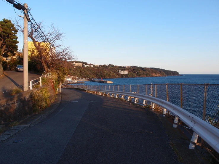 a narrow winding street by an ocean