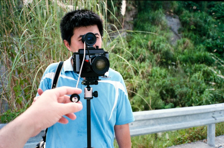 a man holding a camera and looking through the lens