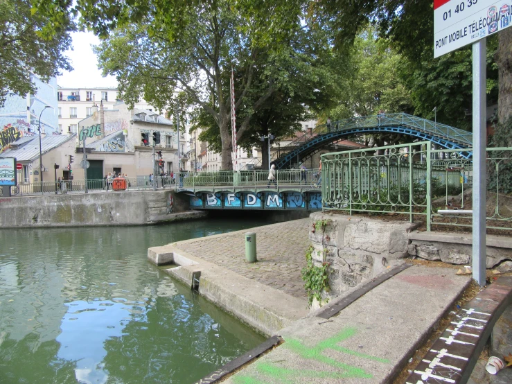 a bridge spanning over a river near a tree line