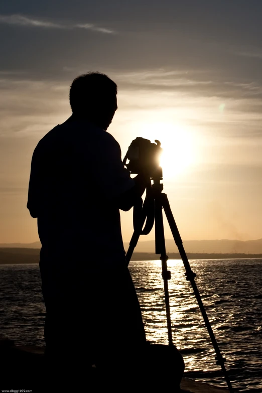 a man that is standing next to a tripod