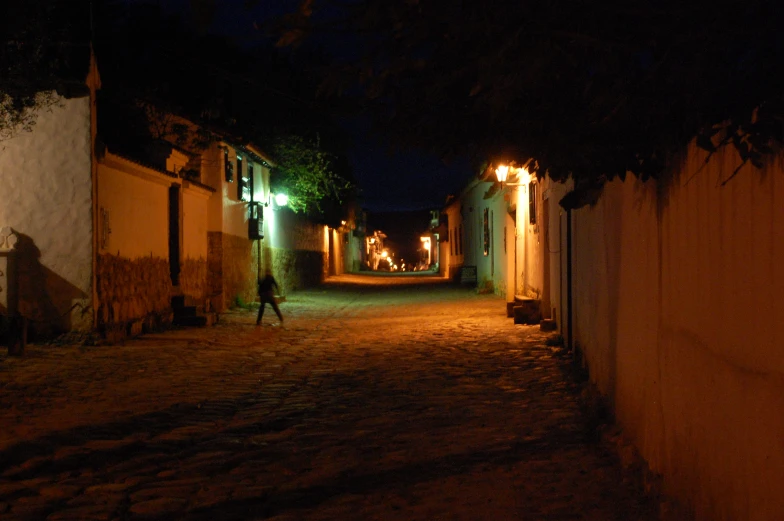 a night scene shows a person walking down an alley