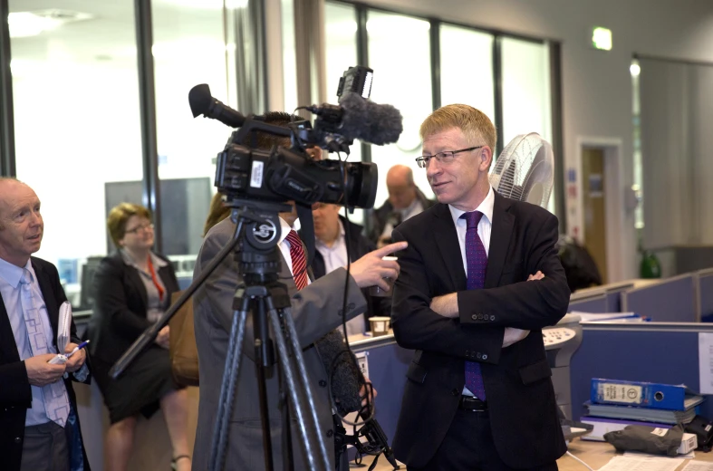 a group of people standing in a building with cameras