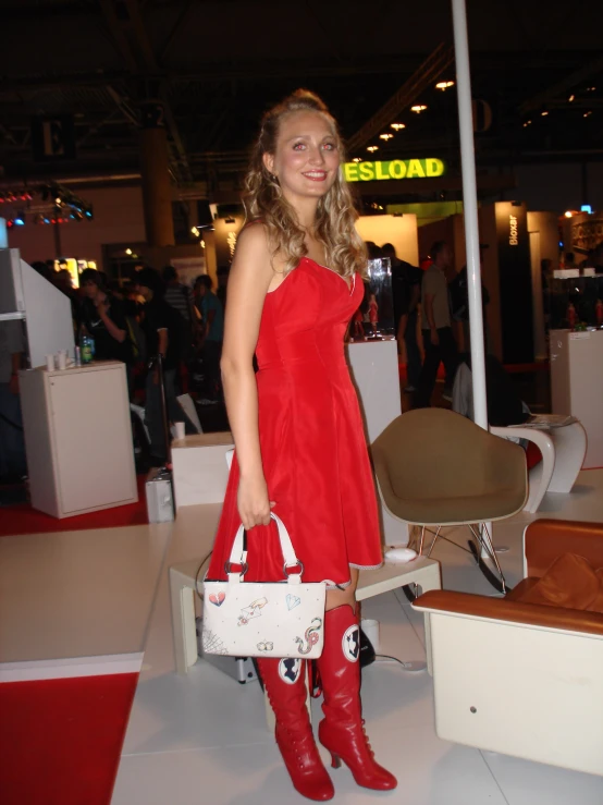 a girl in a red dress is holding a white handbag