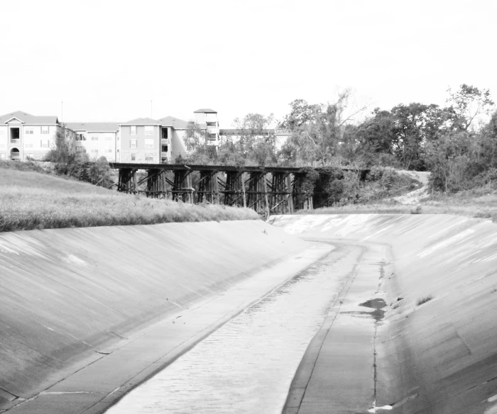 the view of a river running underneath a bridge with houses on it