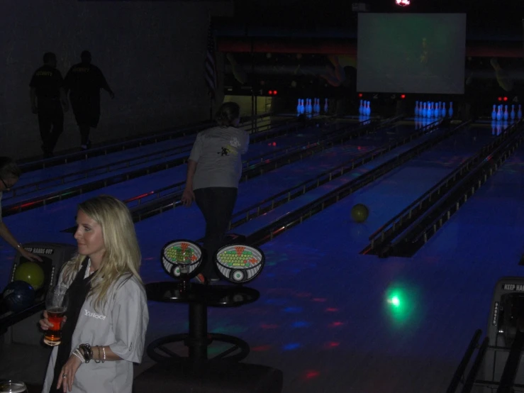 people standing at the end of a bowling alley at night