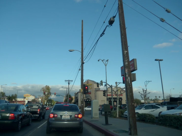 several vehicles parked at an intersection on a sunny day