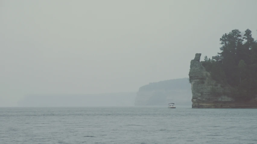 a boat sails in front of an old, crumbling building