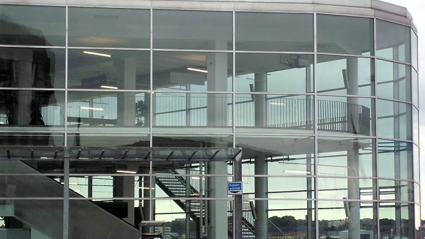 a building has a bunch of glass windows and an open stair case