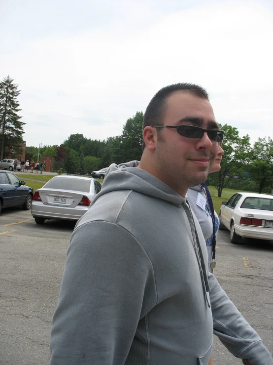 a guy wearing shades in a parking lot