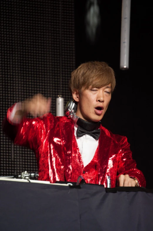 a man in a red suit talking on a microphone