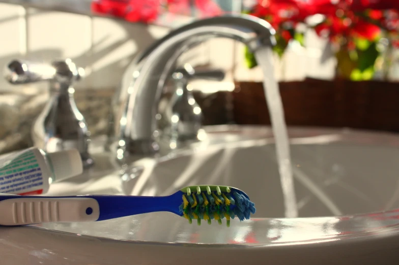 a toothbrush is seen sitting in front of a sink faucet