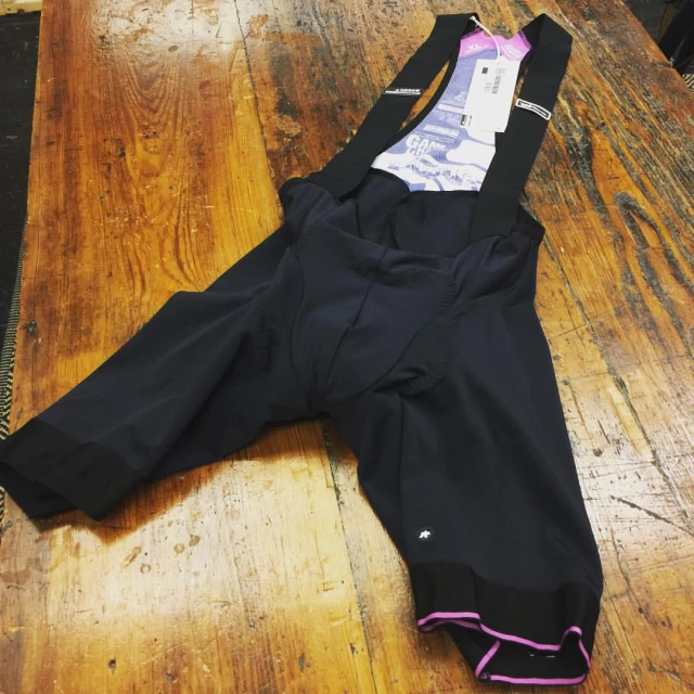 a pair of cycling pants with a purple trim is laying on the floor