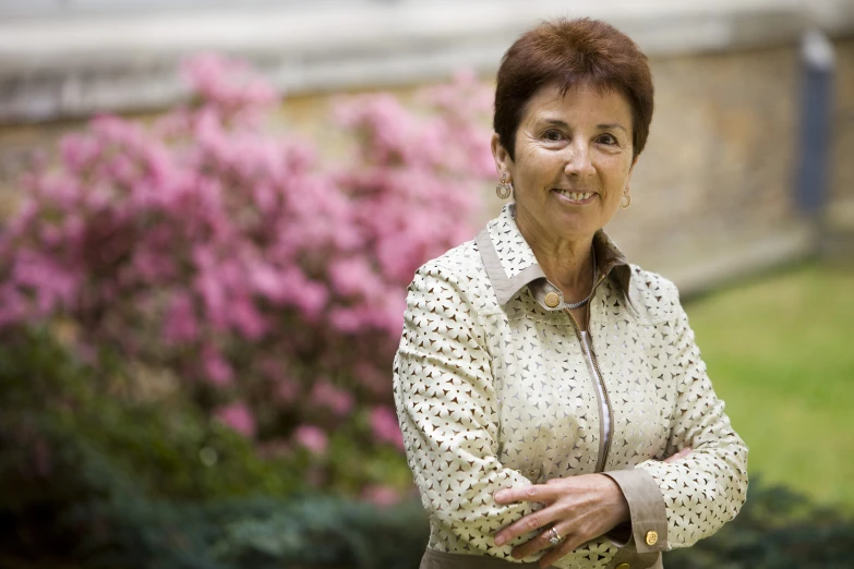 a woman in white shirt with flowers behind her