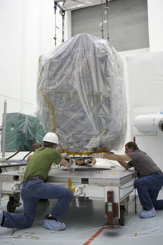 workers install the antenna to the satellite