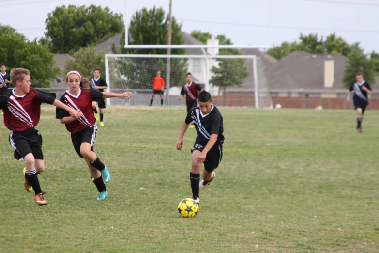 a group of young people play a game of soccer