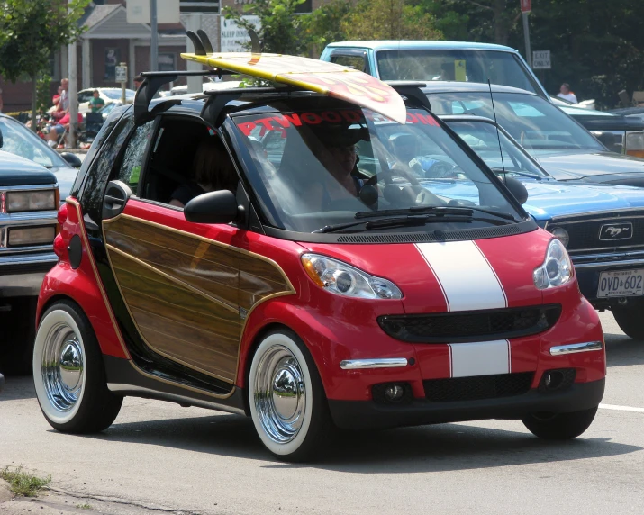 a smart car with a surfboard on top