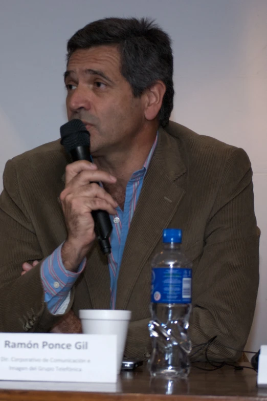 man sitting in front of a microphone at a meeting