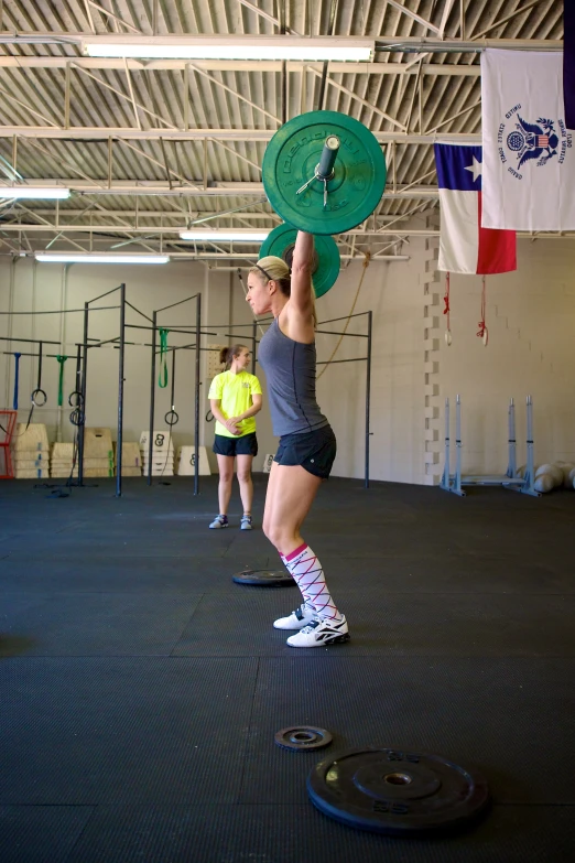 woman doing a squat in gym with exercise equipment